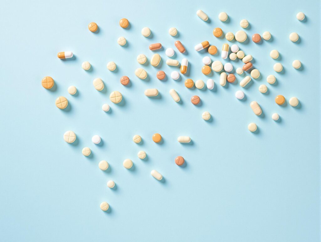 Assortment of Supplement Capsules on Pale Blue Background